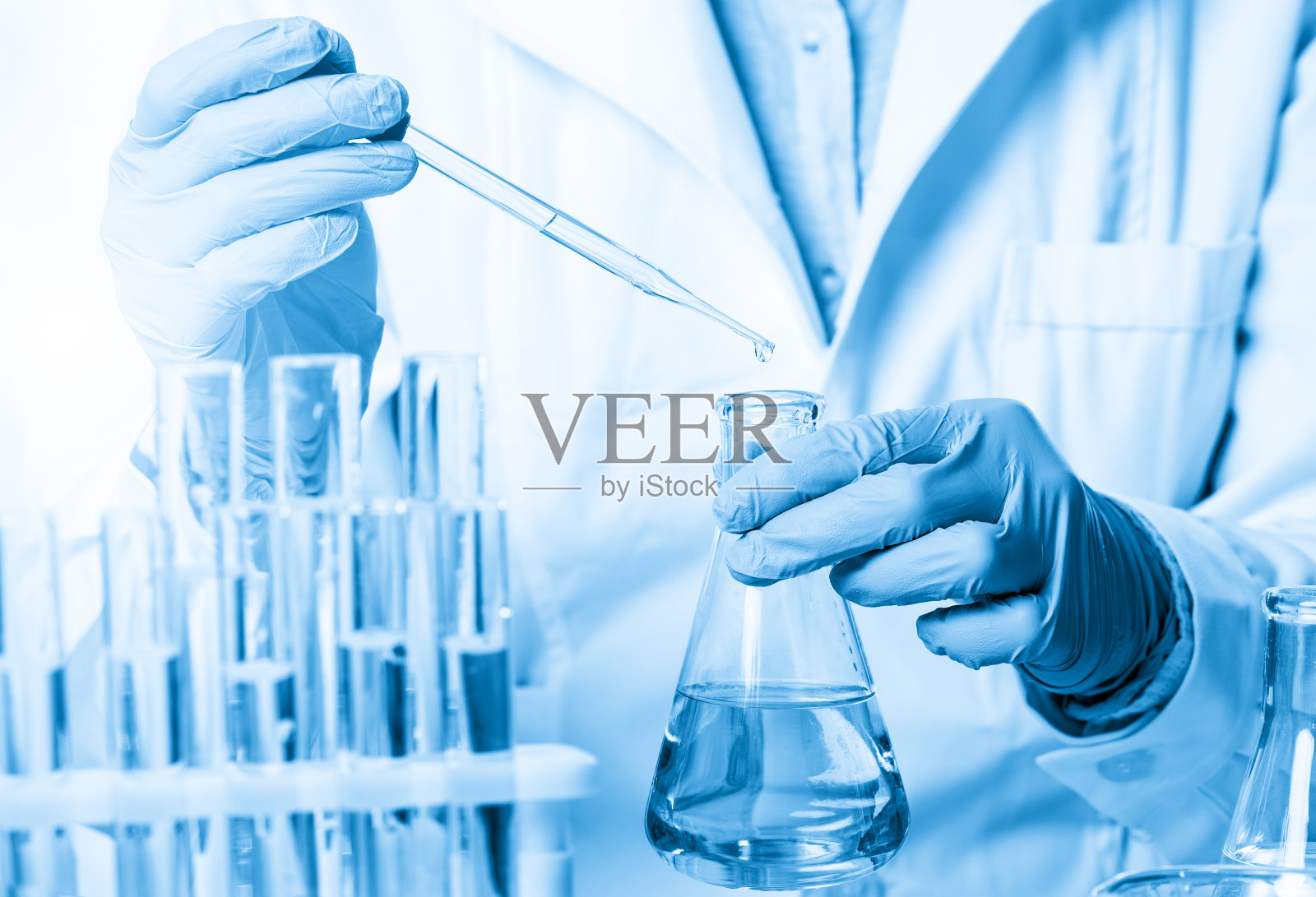 实验室烧杯和试管，分析人员手里拿着塑料手套照片摄影图片