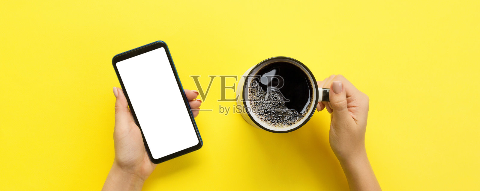 女性手握黑色手机与空白白屏幕和一杯咖啡。模型图像与复制空间为您设计。俯视图旗帜上的黄色背景，平躺照片摄影图片
