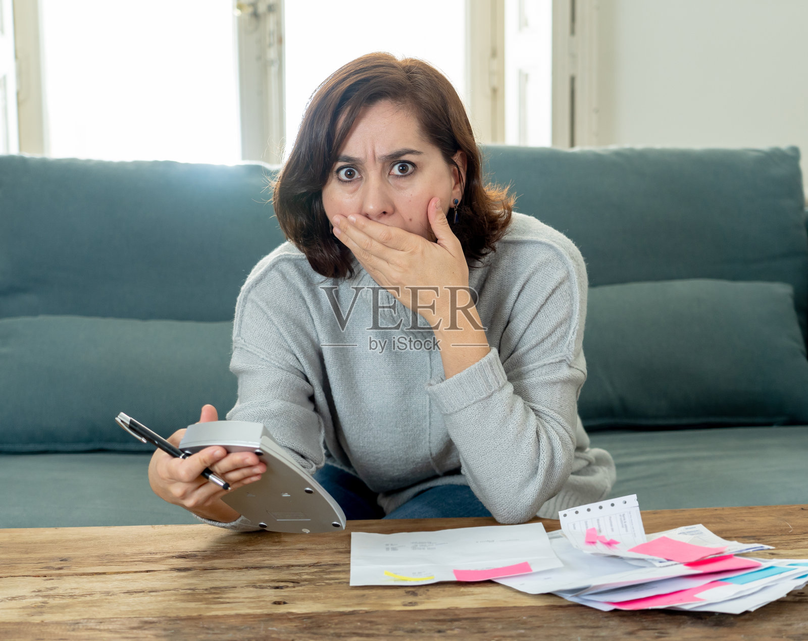 年轻有吸引力的女人看起来很紧张，担心信用卡付款和家庭财务会计成本，费用，税收和抵押贷款在支付账单，财务问题和信用卡债务的概念。照片摄影图片