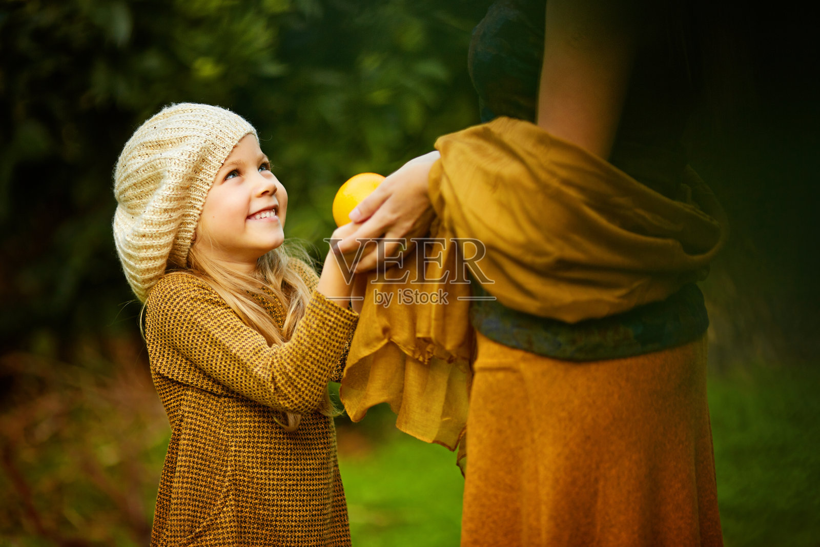 快乐的女孩和妈妈在绿色花园里照片摄影图片