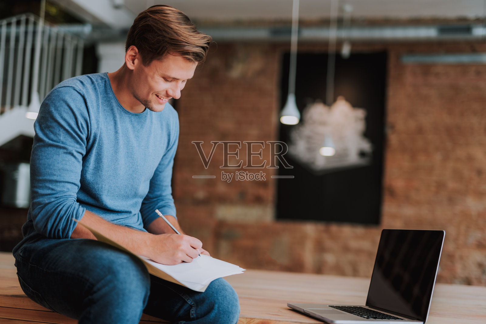 微笑的男人在纸上做笔记照片摄影图片