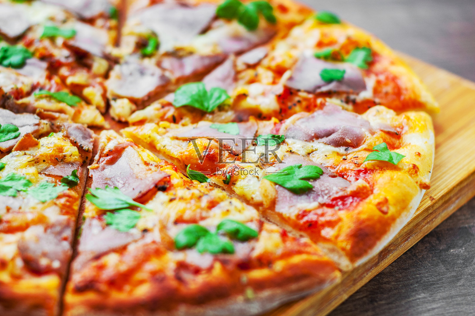 披萨配马苏里拉芝士，火腿，胡椒，肉，番茄酱，香料和新鲜罗勒。木质背景的意大利披萨照片摄影图片