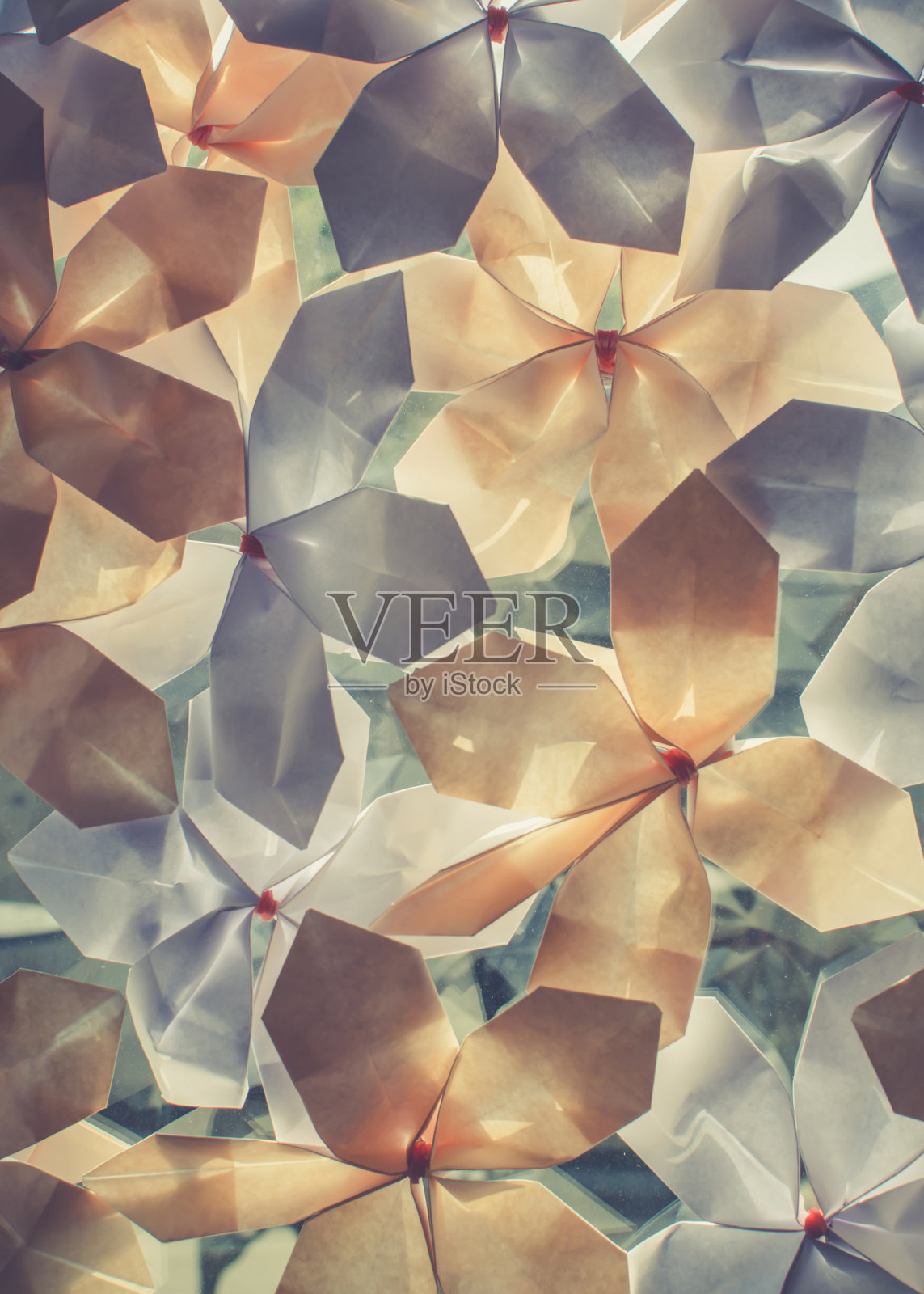 玻璃上粘着蓝色和橙色的纸花。照片摄影图片