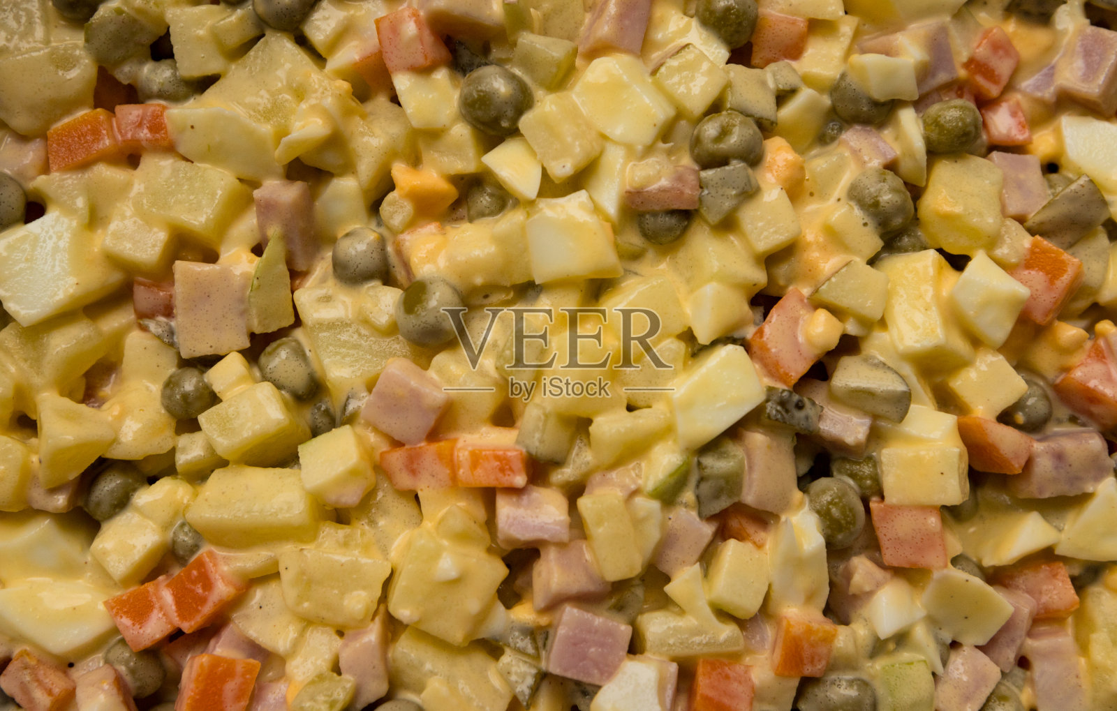 这是一道俄罗斯(法国)沙拉，里面有自制的蛋黄酱、豌豆、黄色奶酪、煮鸡蛋、火腿、胡萝卜、土豆、腌黄瓜照片摄影图片