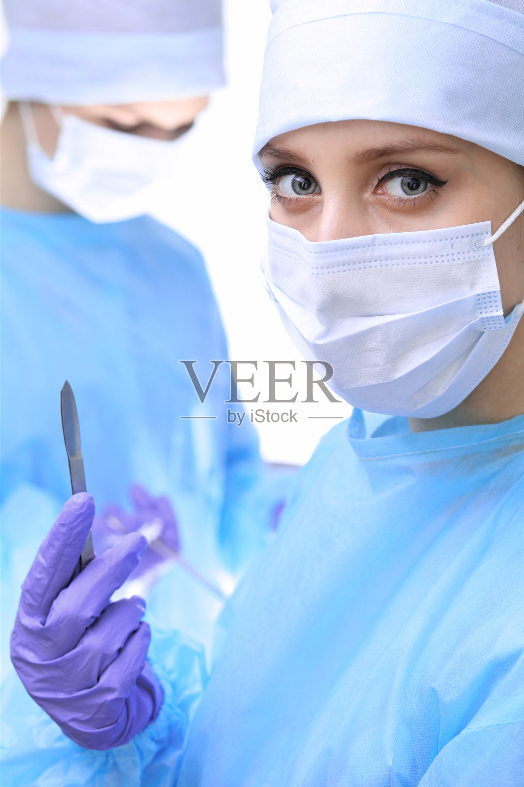 外科医生戴着口罩进行手术。关注女实习生。医学，急救概念照片摄影图片