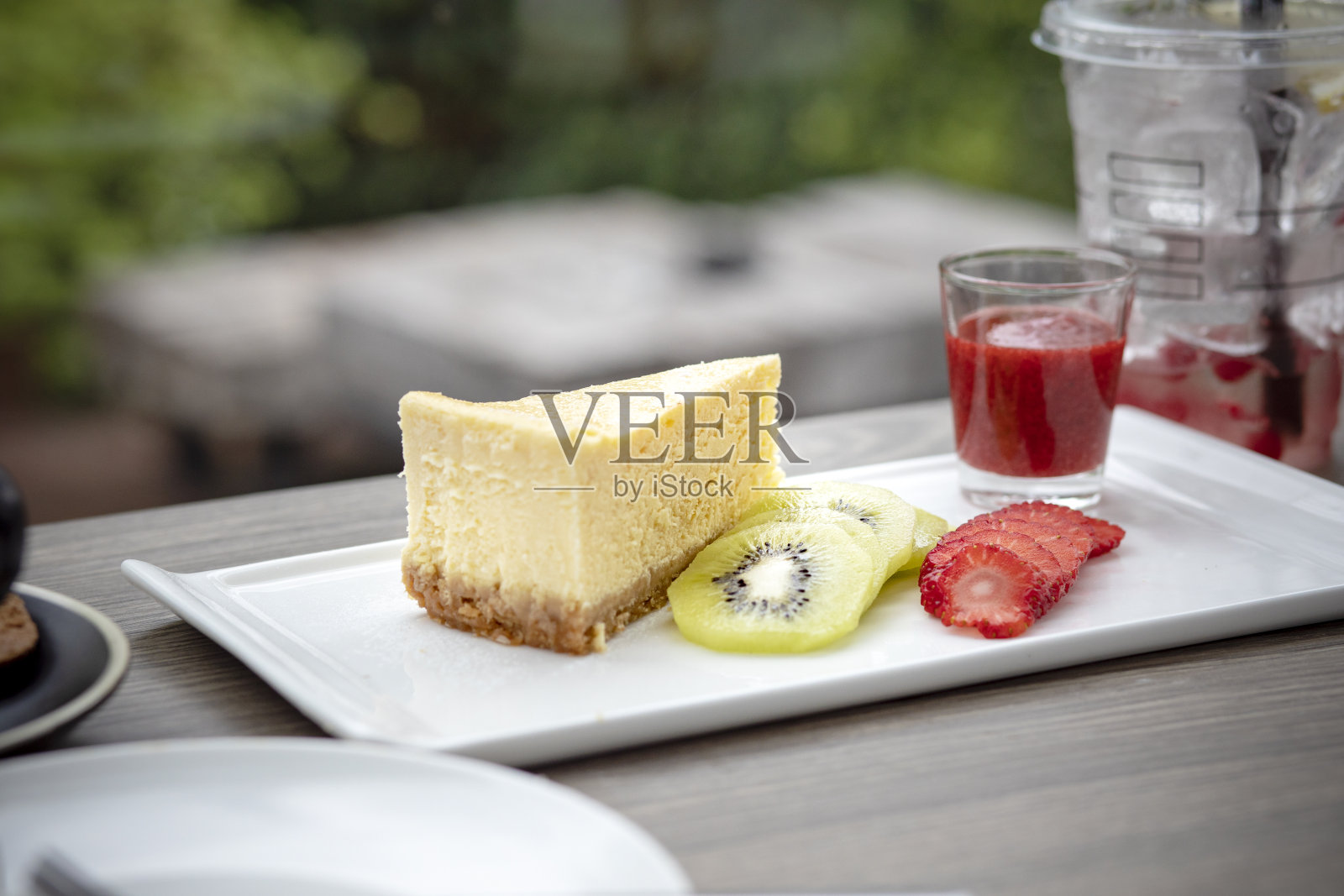 用猕猴桃和草莓片装饰的芝士蛋糕即可食用照片摄影图片