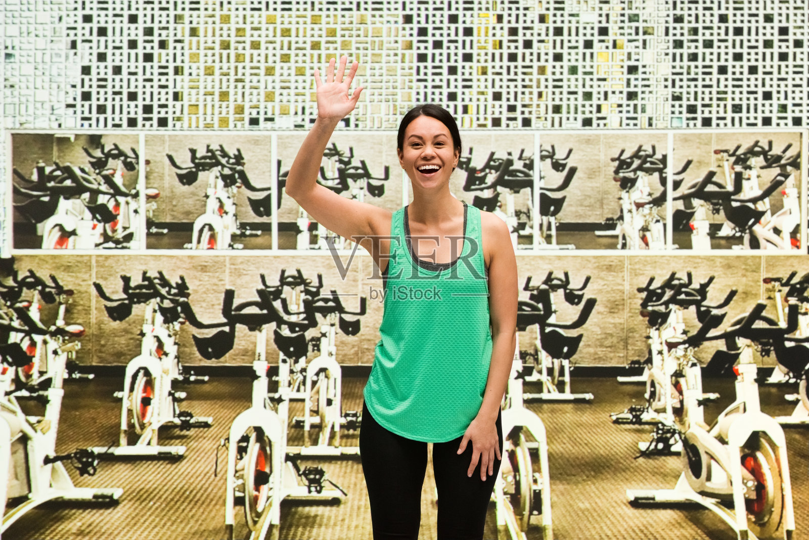 美丽的女性在自行车练习室招手照片摄影图片