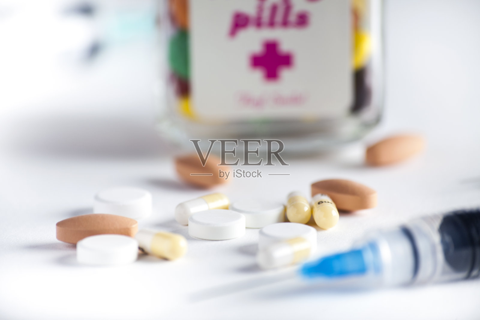 疫苗和药片放在白色的背景上。注射器、医疗注射。医用塑料接种器具用针。液体药物或麻醉剂。医院的医疗保健。——图片照片摄影图片