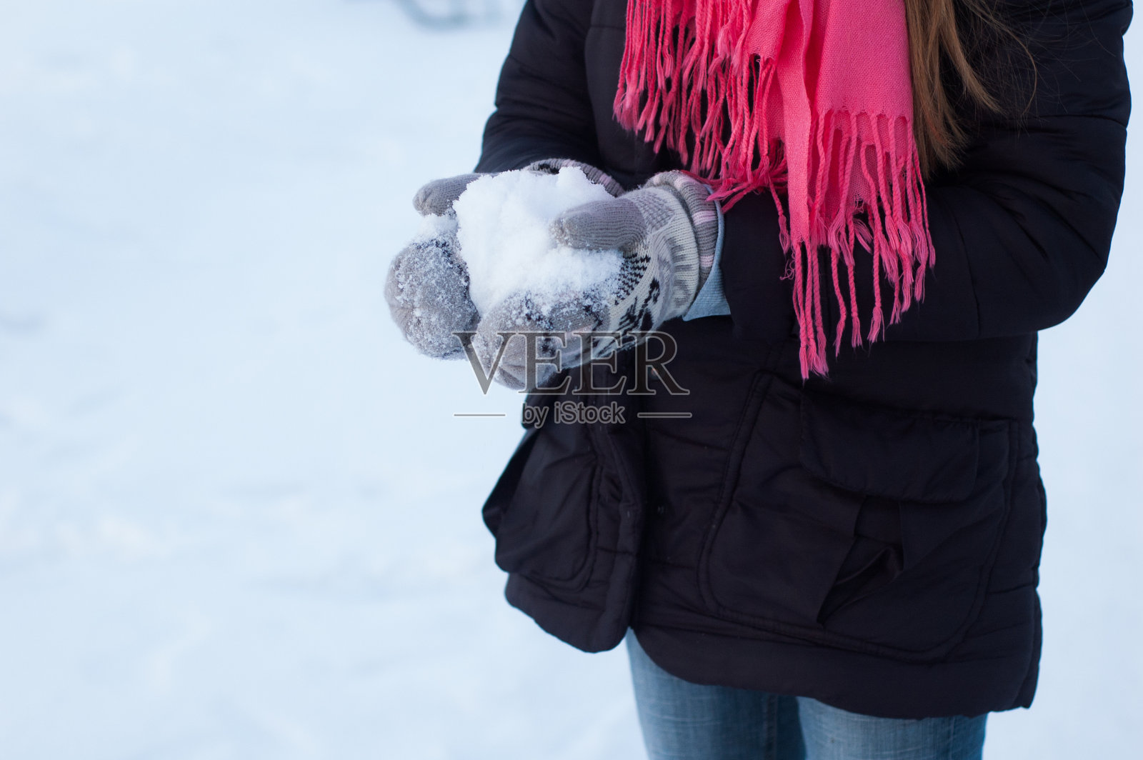 这个女孩手里拿着雪。照片摄影图片