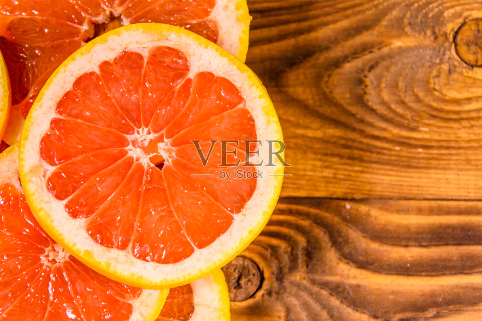 切好的多汁葡萄柚放在木桌上。俯视图照片摄影图片