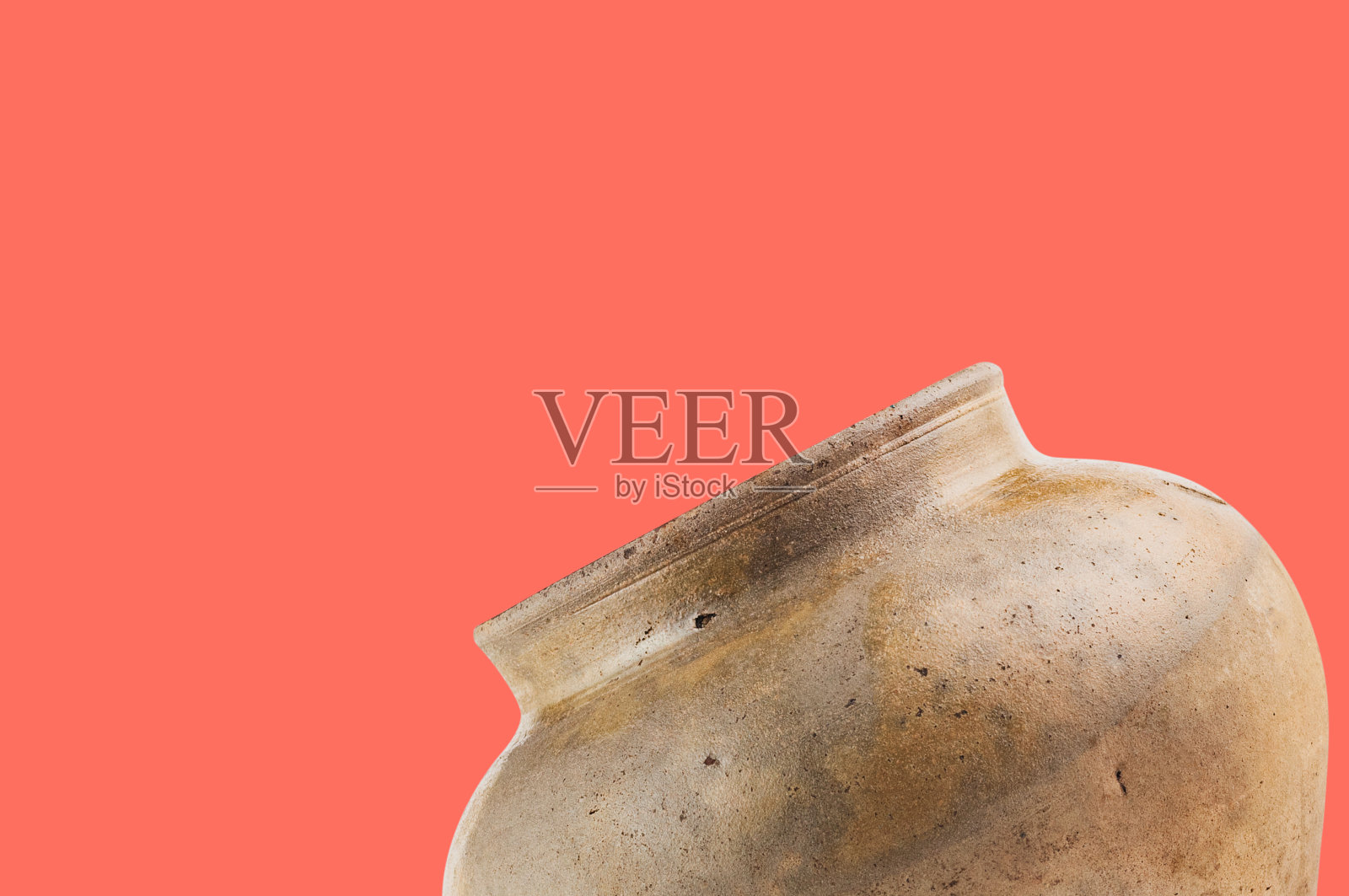 珊瑚色的桌子上放着一个又旧又脏的花瓶，上面有放文字的空间。考古挖掘的概念照片摄影图片