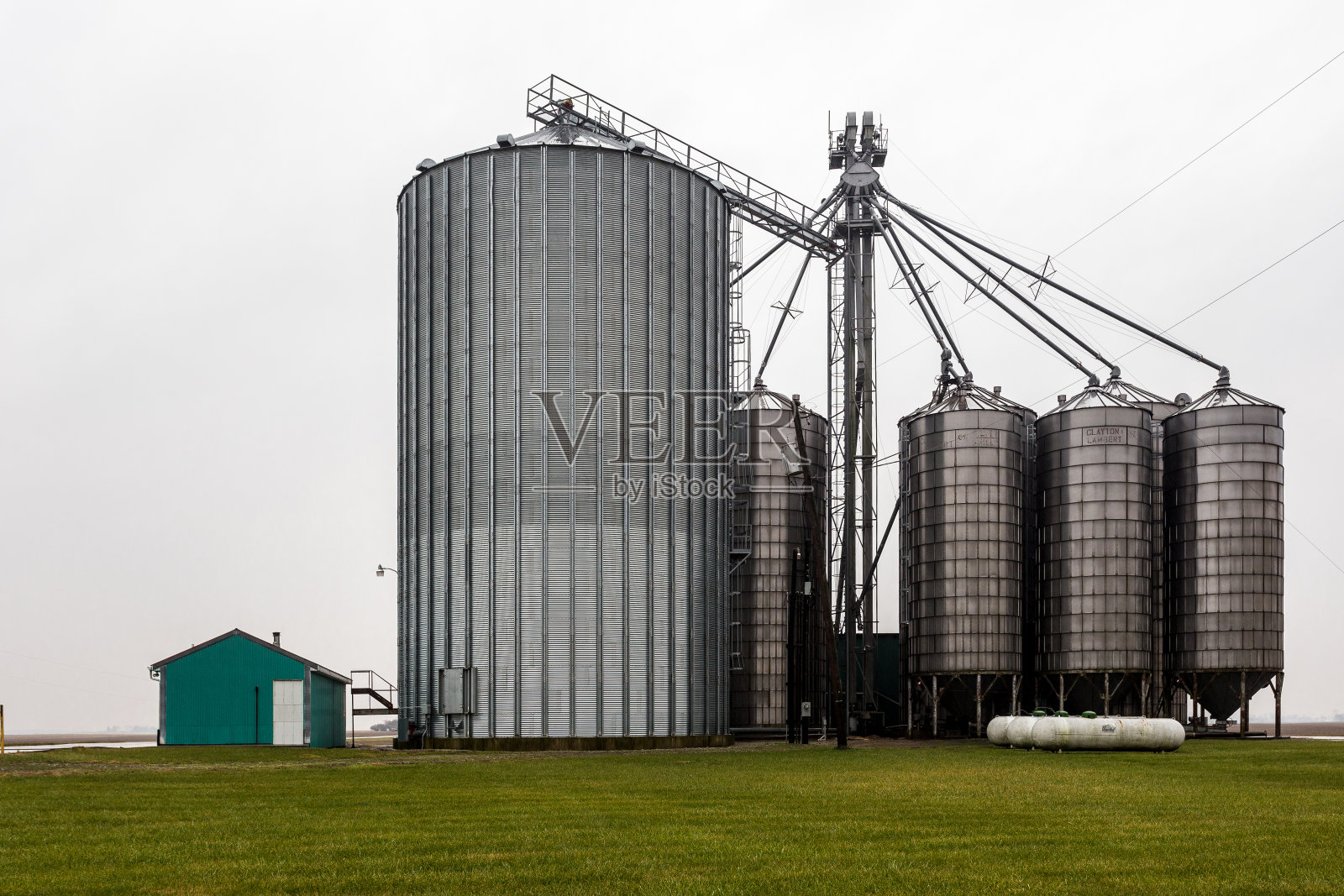 有绿色建筑和草的农场筒仓在雾天照片摄影图片
