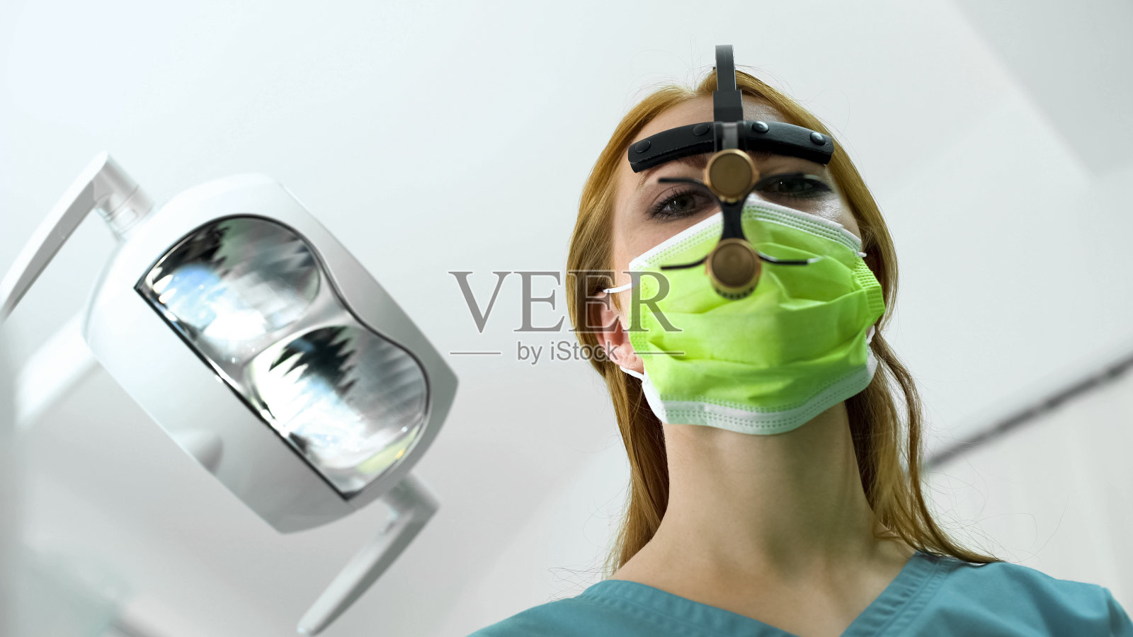 戴眼镜检查口腔的女牙医，现代口腔医学，病人POV照片摄影图片