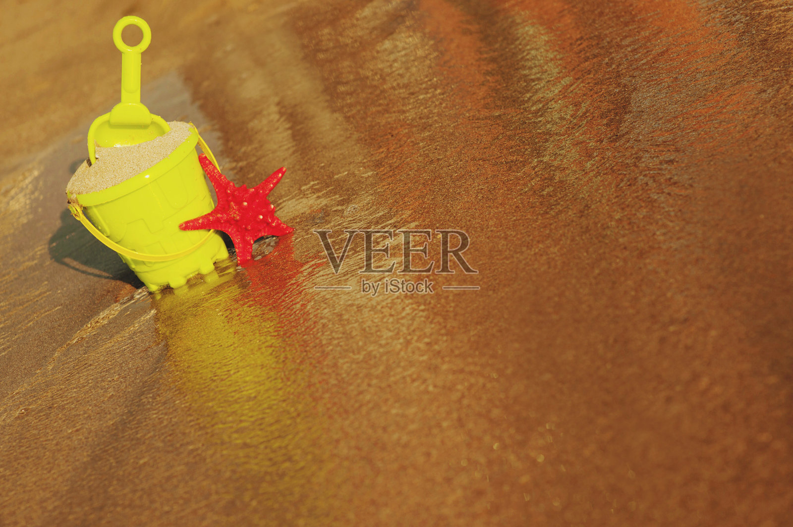 夏天的假期。在沙滩上的桶和铲子。明亮的塑料儿童玩具在沙滩上。儿童沙滩娱乐的概念。前视图。文本空间，拷贝空间照片摄影图片