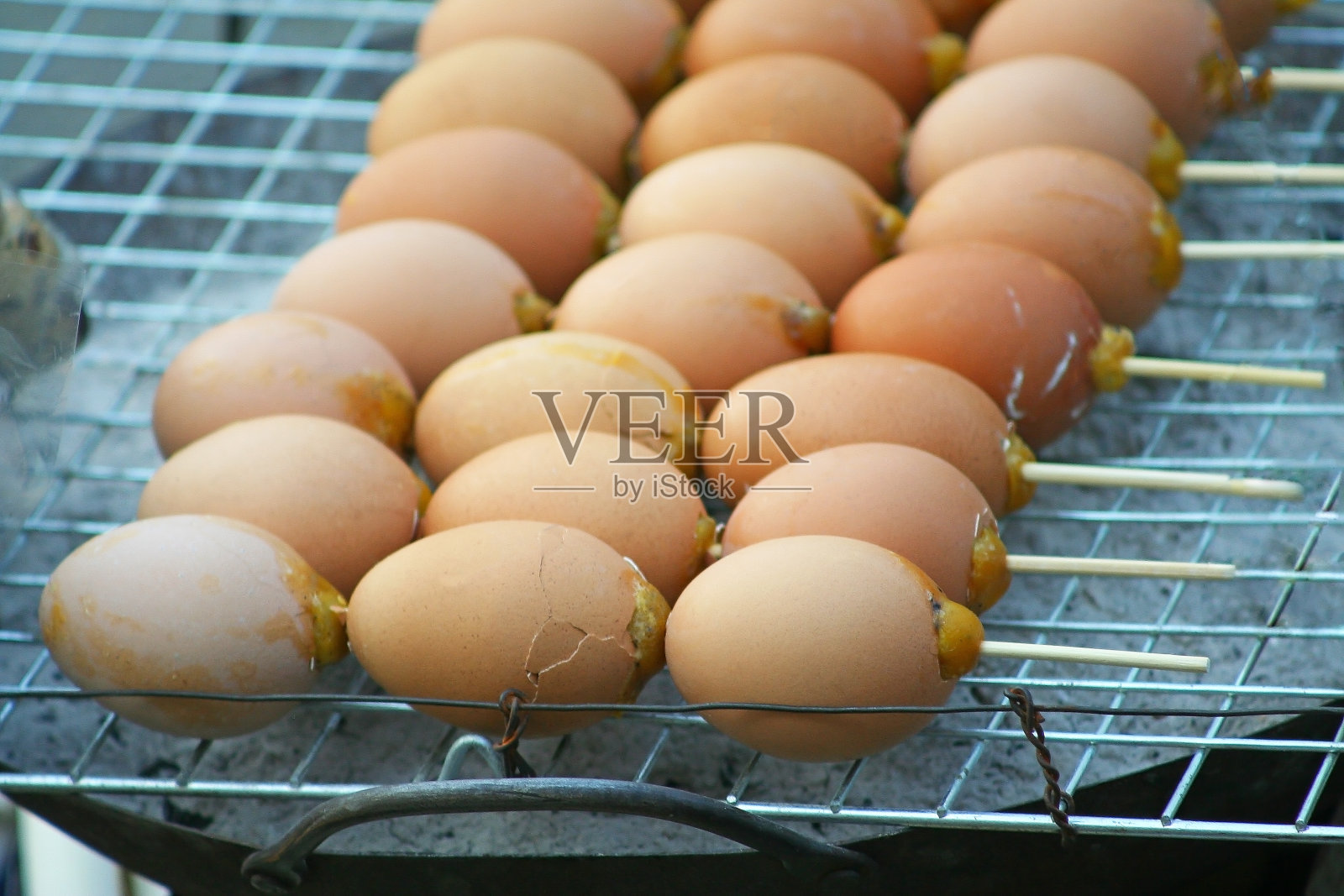 在市场的钢炭烤架上烤鸡蛋照片摄影图片