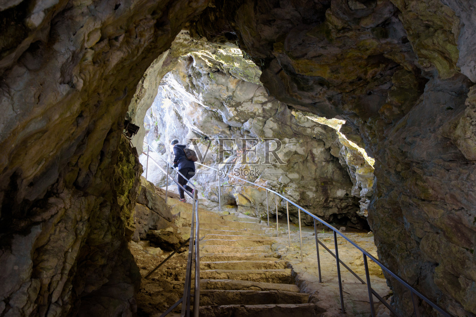在斯洛文尼亚美丽的Predjama城堡里，一个人正在爬石阶照片摄影图片