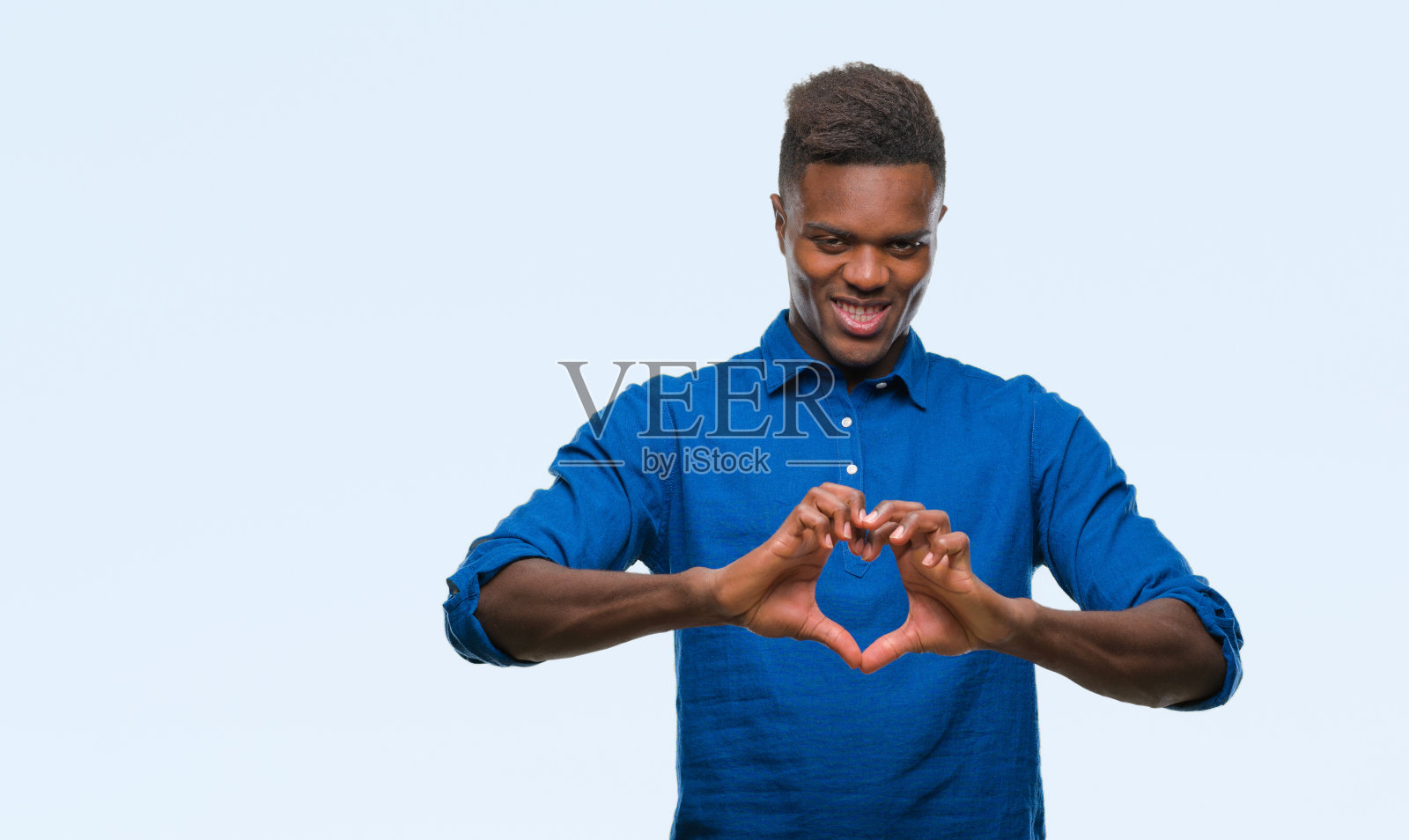 年轻的非洲裔美国人在孤立的背景微笑在爱显示心形符号和形状的手。浪漫的概念。照片摄影图片