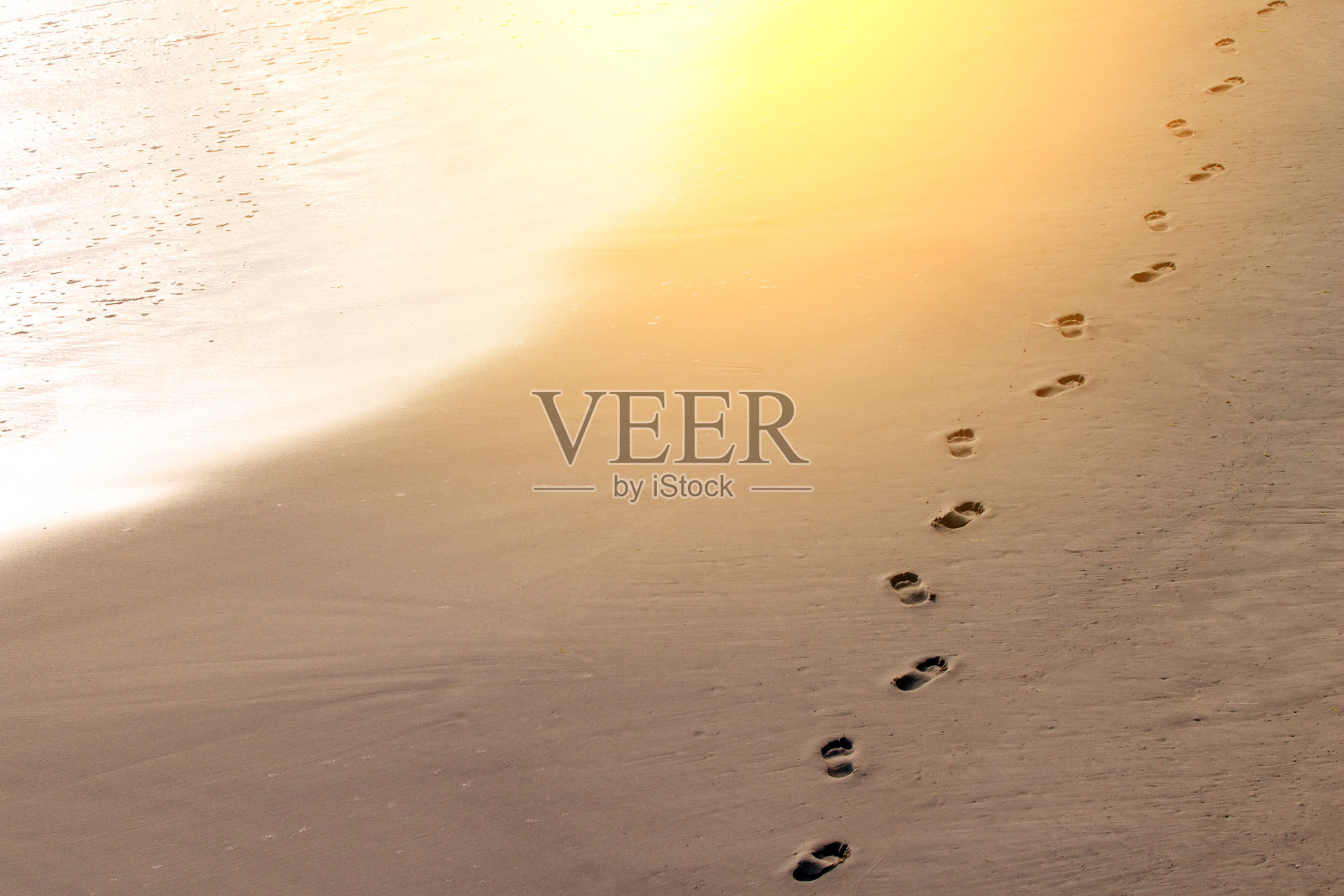 脚印在海边的沙滩上，调色了照片摄影图片