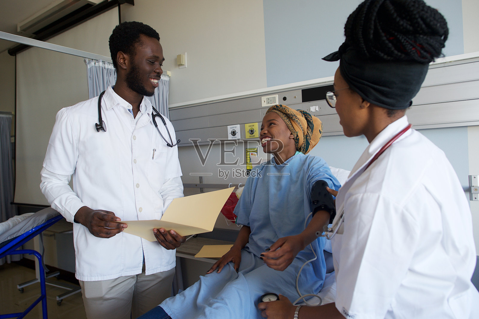 男医生和女医生给病人量血压说话微笑照片摄影图片