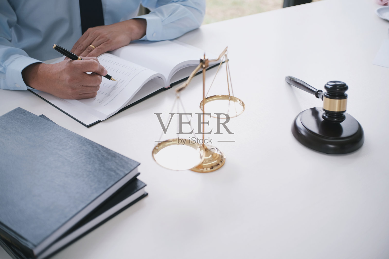 法律顾问向客户提交一份用木槌和法律条文签署的合同。正义与律师的概念。照片摄影图片