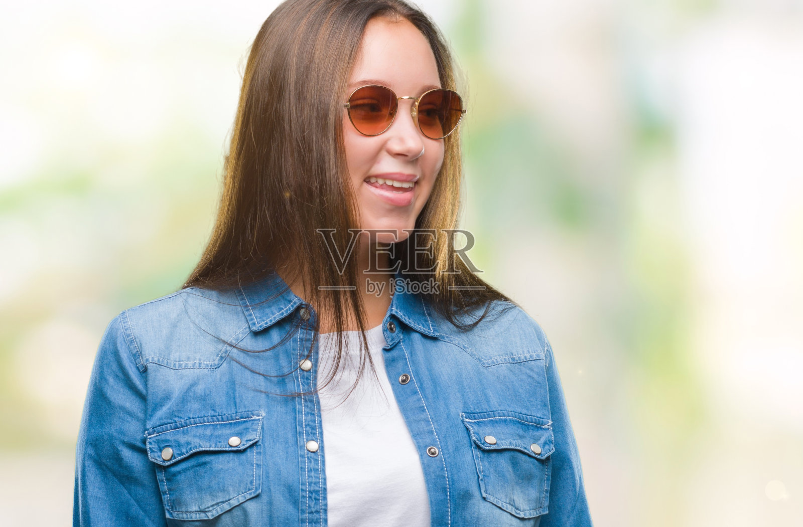 年轻美丽的白人妇女戴着太阳镜孤立的背景看向一边，脸上微笑，自然的表情。自信的笑。照片摄影图片