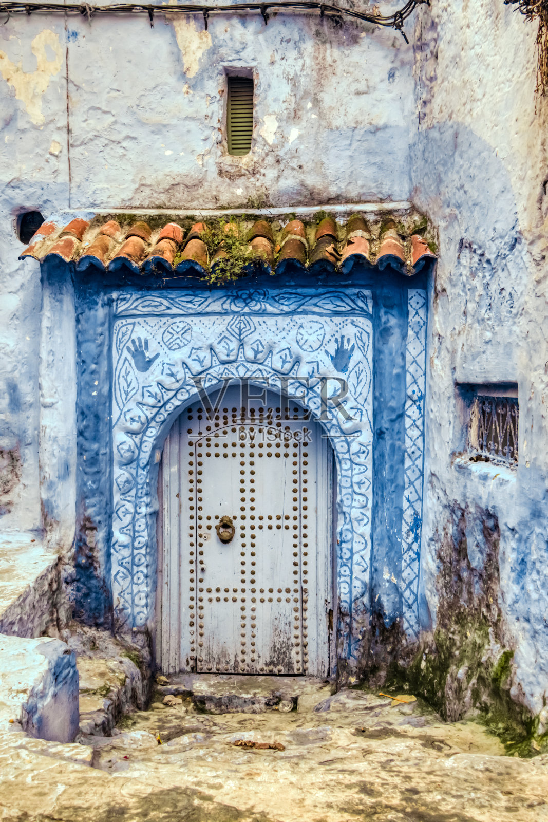 摩洛哥Chaouen的一座带有大木门的老房子的正面照片摄影图片