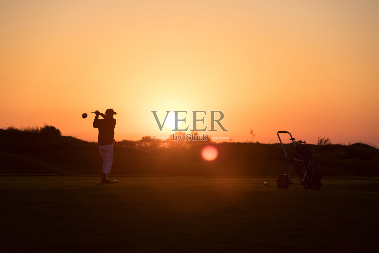 高尔夫球员击球-链接高尔夫-日落时间照片摄影图片