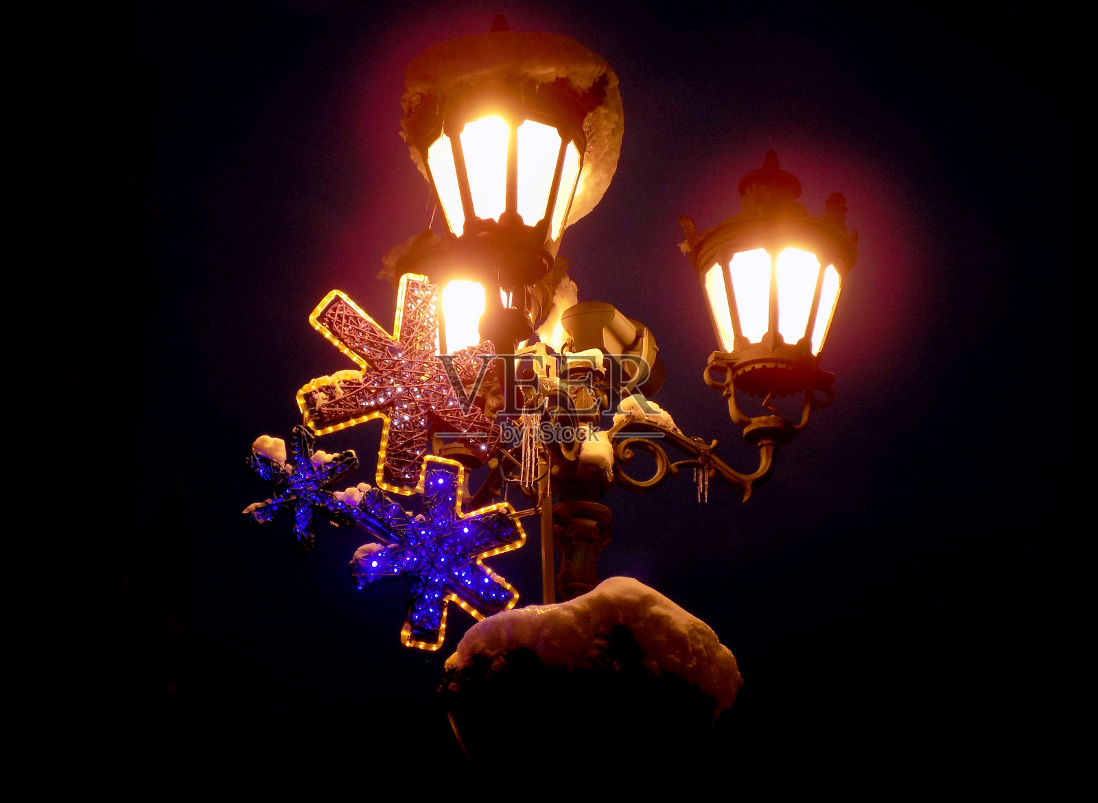 带有圣诞装饰的复古风格街灯，上面覆盖着雪花照片摄影图片