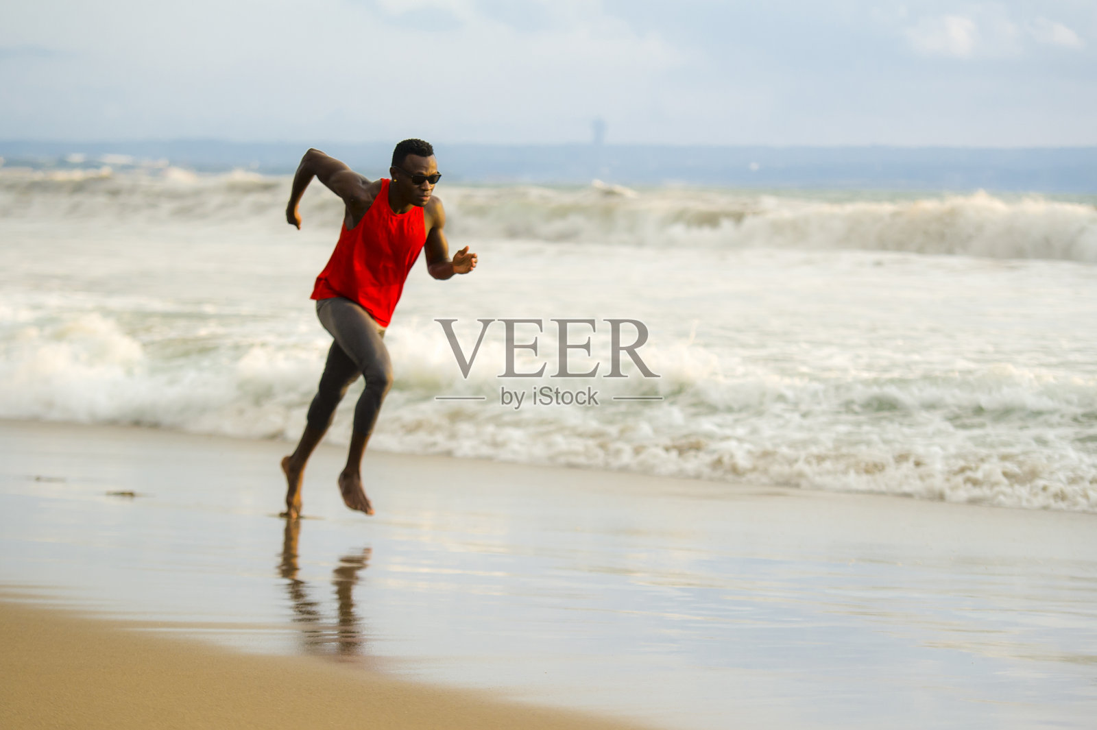 年轻有吸引力的健美运动和强壮的黑人美国人在海滩上跑步刻苦训练和在海水上短跑在职业运动员的生活方式和ripped runner锻炼照片摄影图片