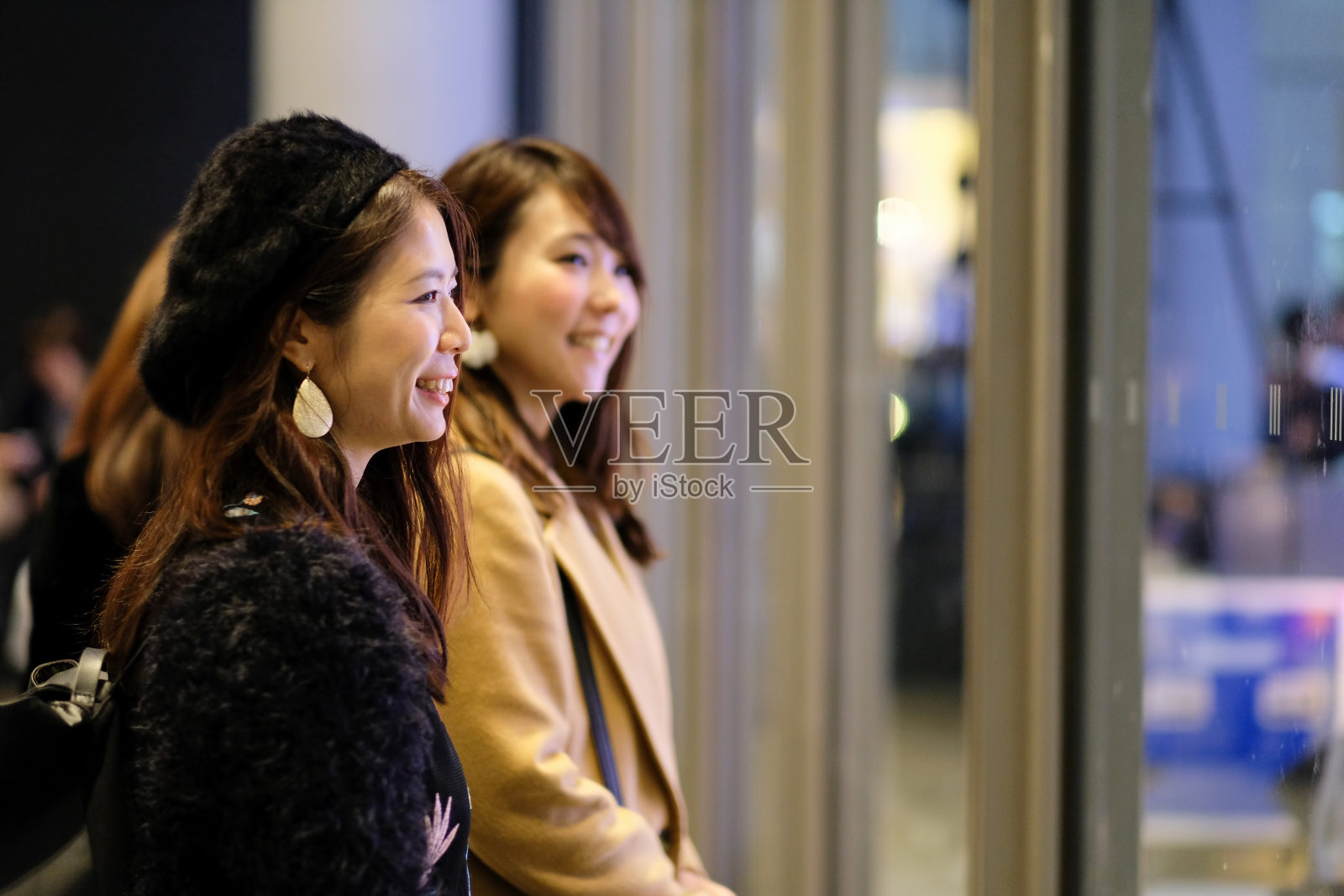 在夜晚的街道上看橱窗的女人照片摄影图片