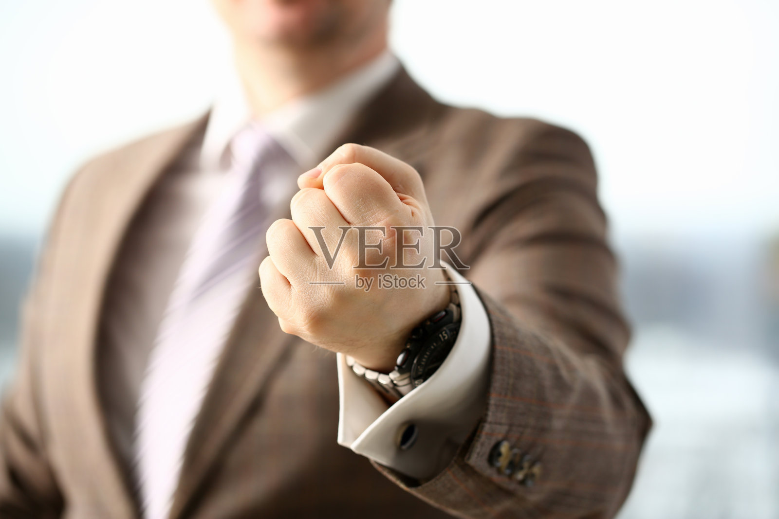 西装男在办公室紧握拳头照片摄影图片