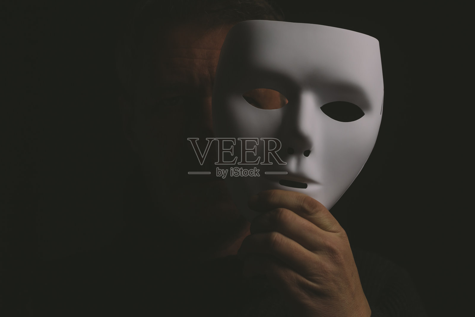 成年男子摘下面具照片摄影图片