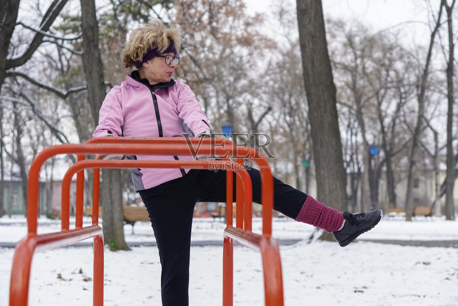 老年妇女在冬季在公园锻炼照片摄影图片