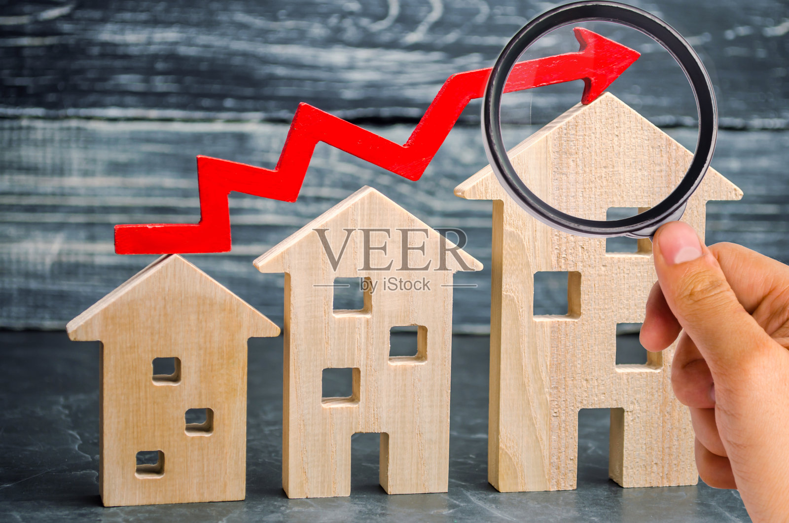 木屋从小到大排成一排，上面有一个红色的箭头。房地产高需求的概念。提高房屋的能源效率。房价上涨。财产。人口增长照片摄影图片