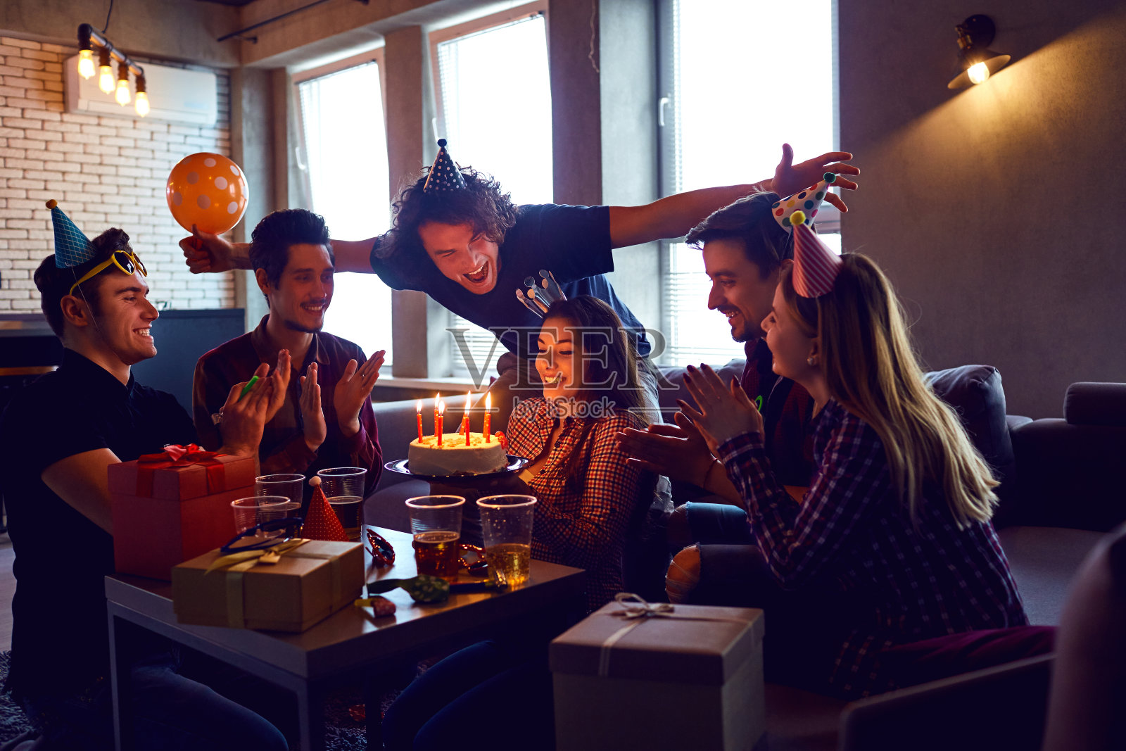 朋友们在聚会上拿着生日蛋糕庆祝生日。照片摄影图片