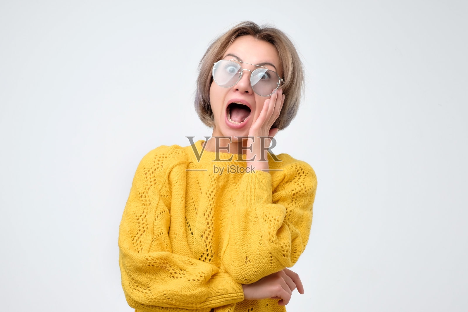 身着黄色毛衣的年轻女子惊呼着这个好消息。照片摄影图片