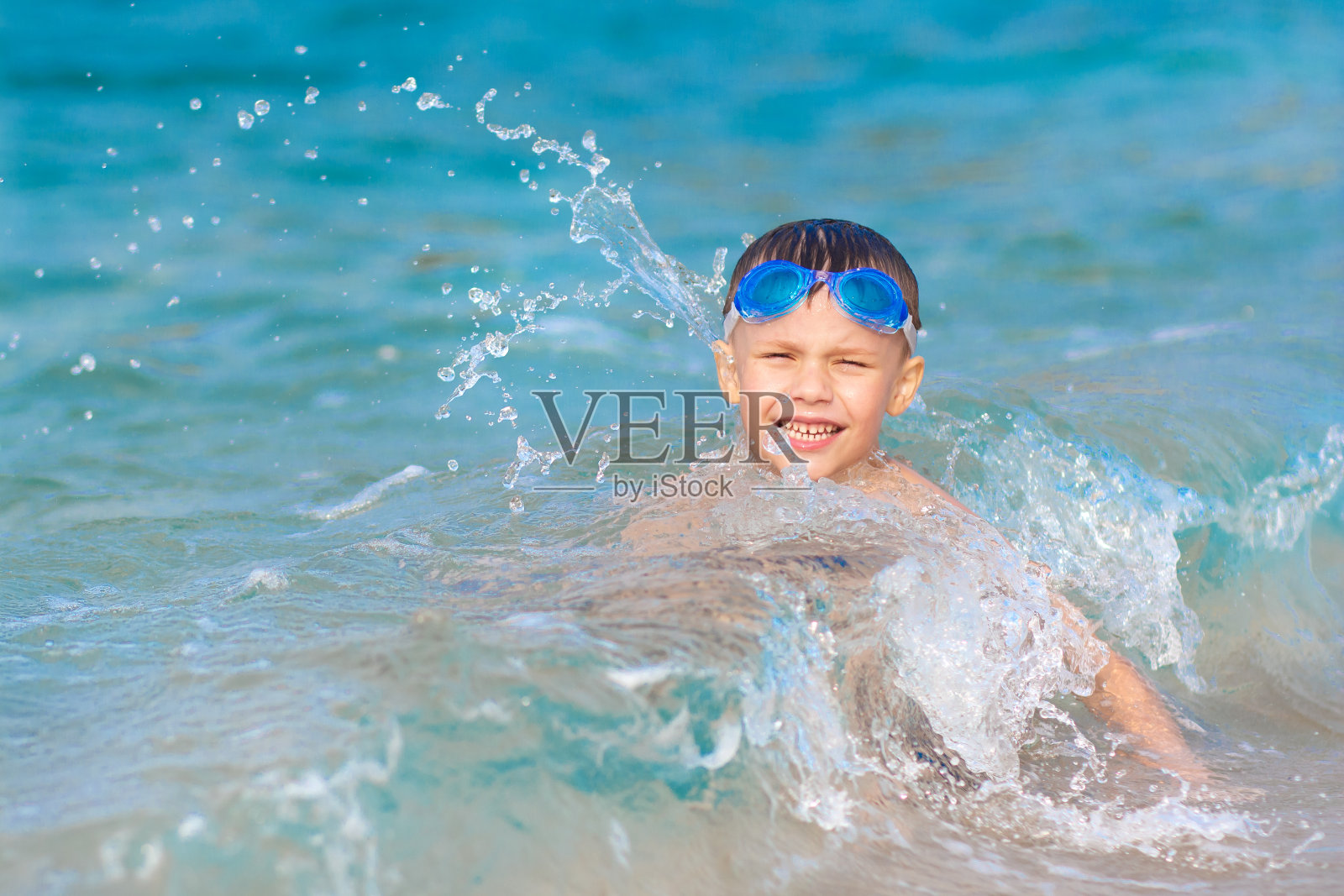 男孩在海水中洗澡照片摄影图片