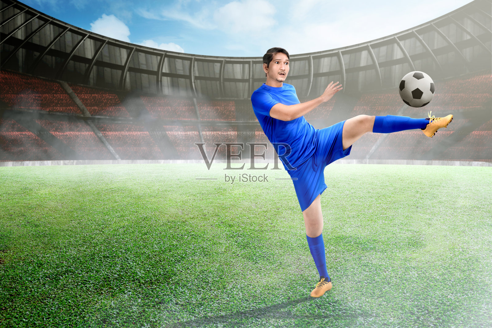 迷人的亚洲足球运动员踢球照片摄影图片