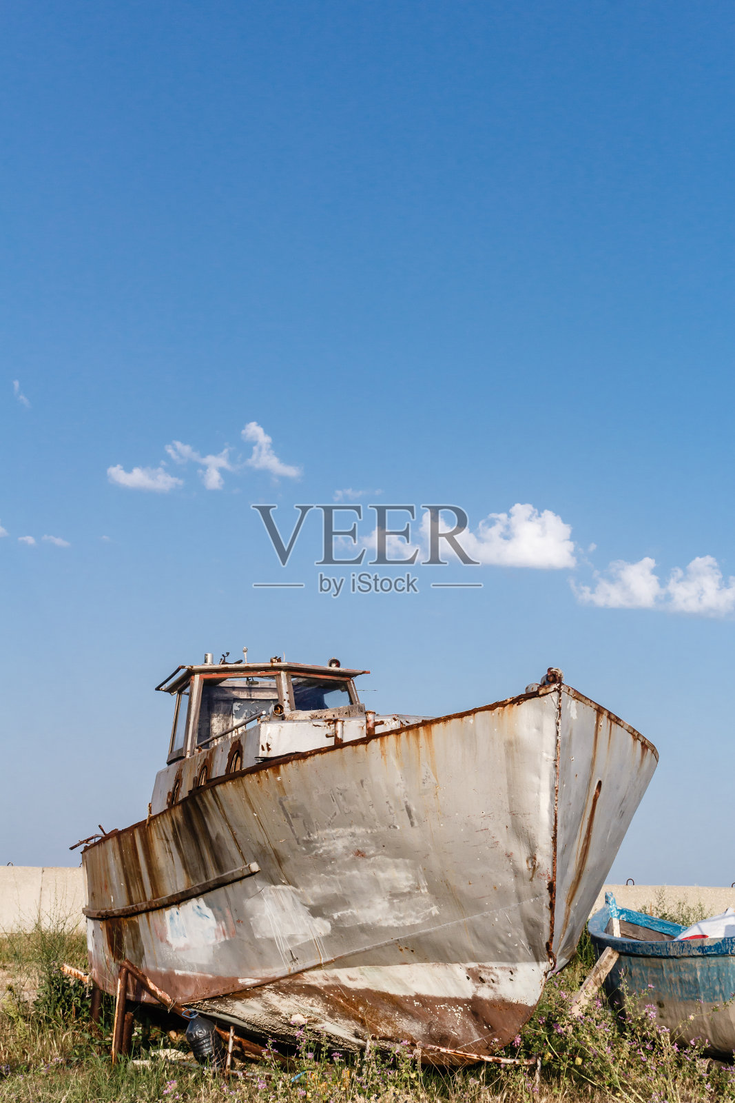 在保加利亚的拜亚拉，一艘废弃的生锈的船停在海岸边，对着蓝天。照片摄影图片