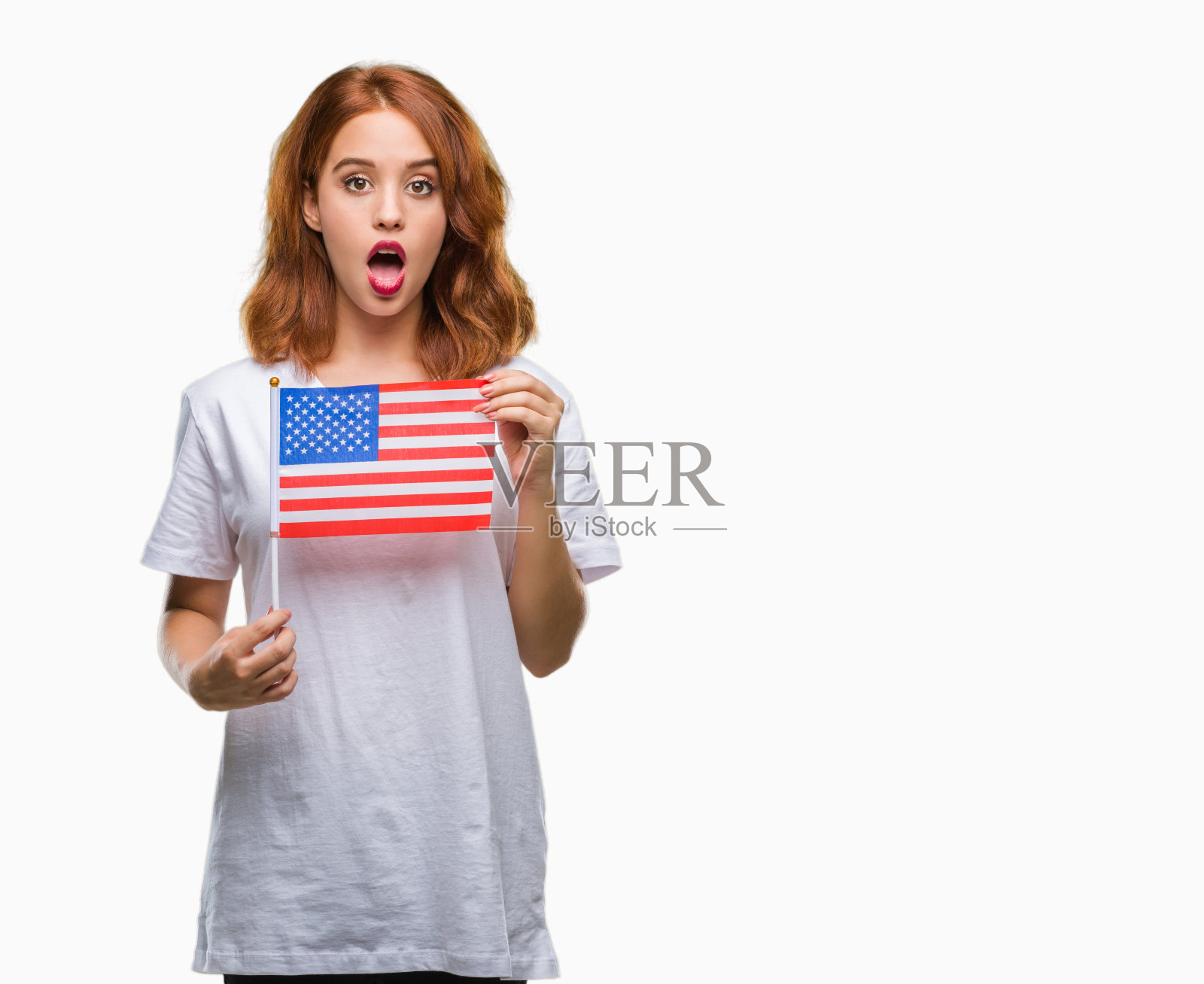 年轻美丽的女人举着美国国旗在孤立的背景害怕在震惊与惊讶的脸，害怕和兴奋与恐惧的表情照片摄影图片