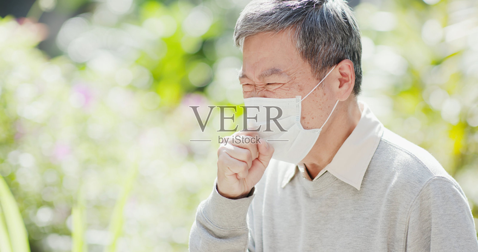 老人在室外咳嗽照片摄影图片