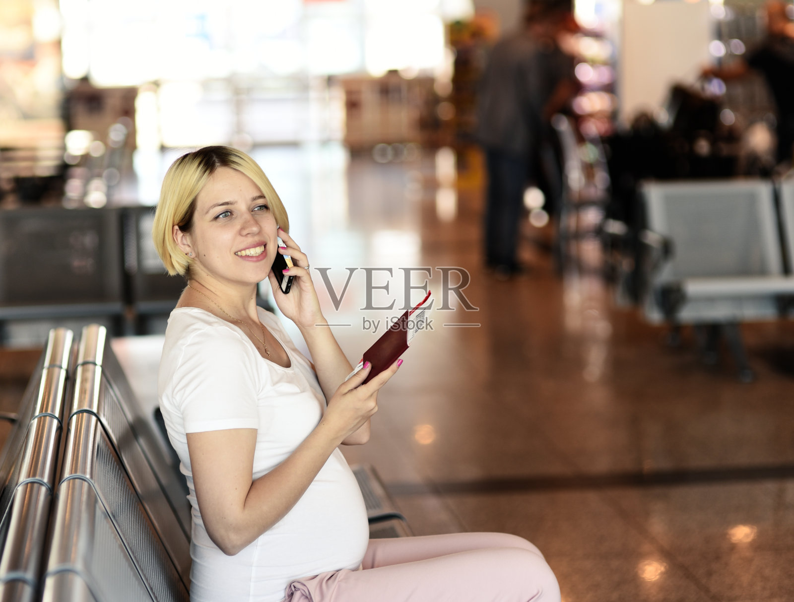 孕妇乘飞机旅行，坐在座位上打电话照片摄影图片