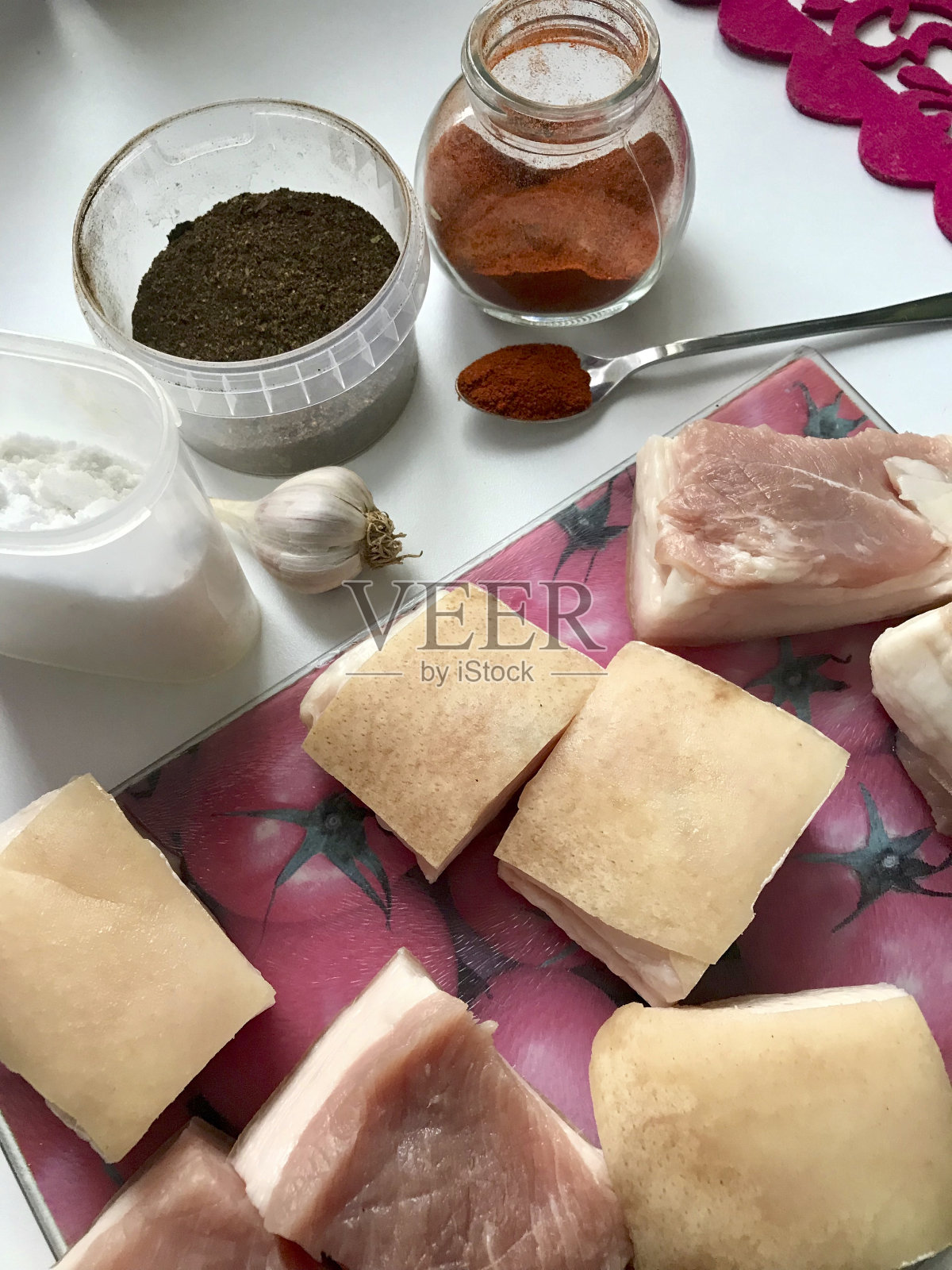 猪油加肉层，切成块。躺在砧板上。靠近大蒜，盐，用来腌制猪油的香料。照片摄影图片