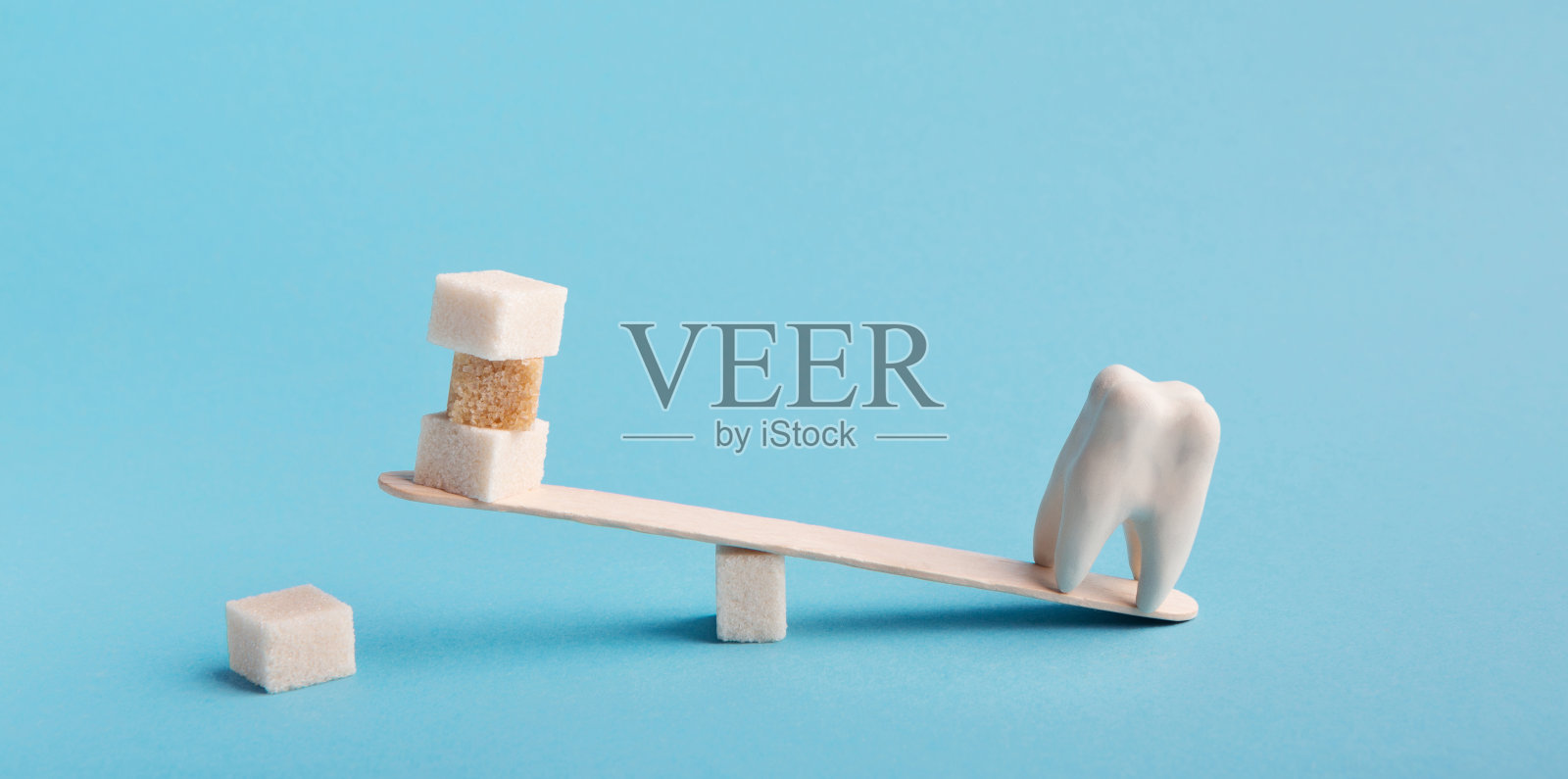 健康的牙齿和糖在跷跷板上平衡照片摄影图片