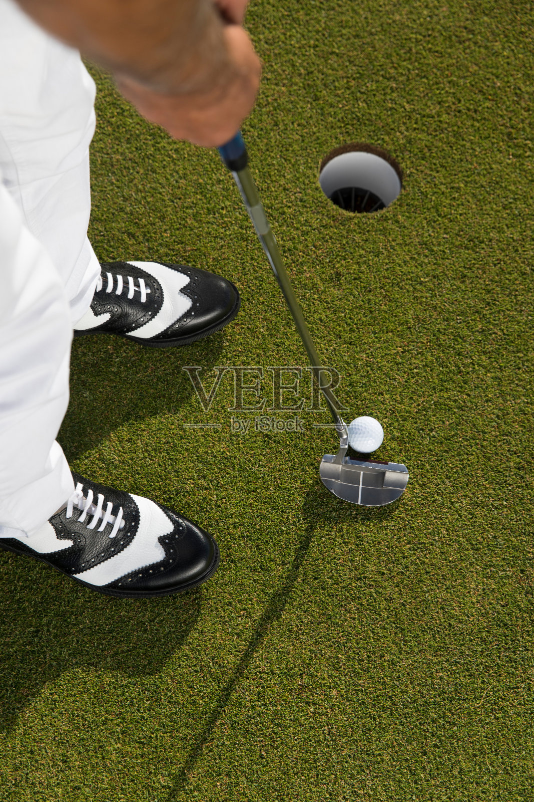 高尔夫球，高尔夫球员把高尔夫球靠近洞-高尔夫球-近距离照片摄影图片