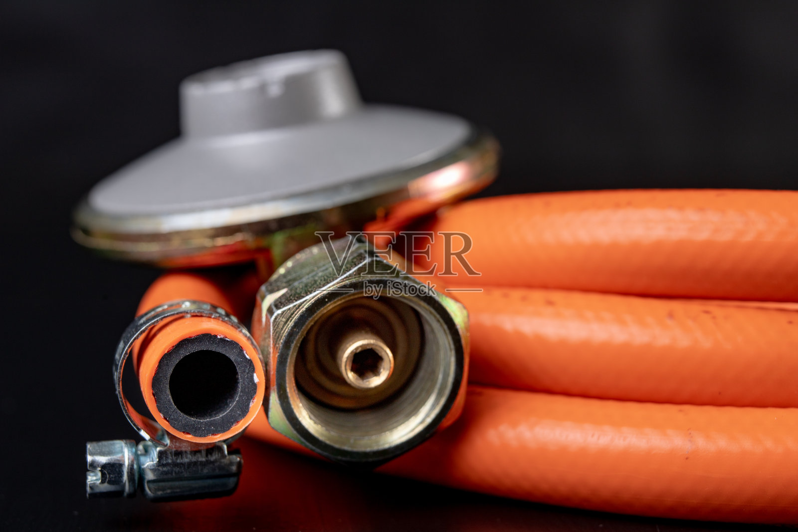 调整器丙烷-丁烷气体钢瓶和附件在一个木制的车间桌子。车间气体附件。照片摄影图片