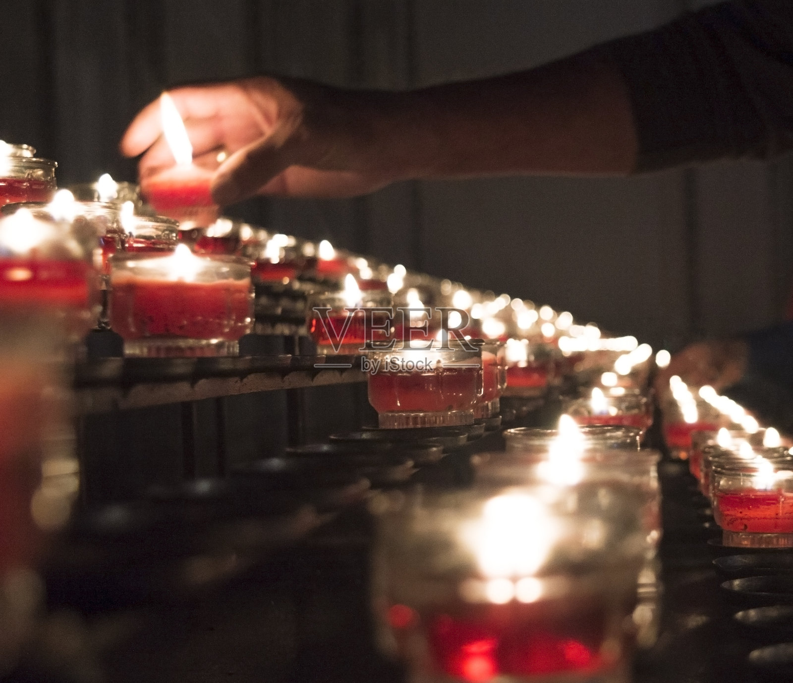 在黑暗中手持燃烧的蜡烛照片摄影图片
