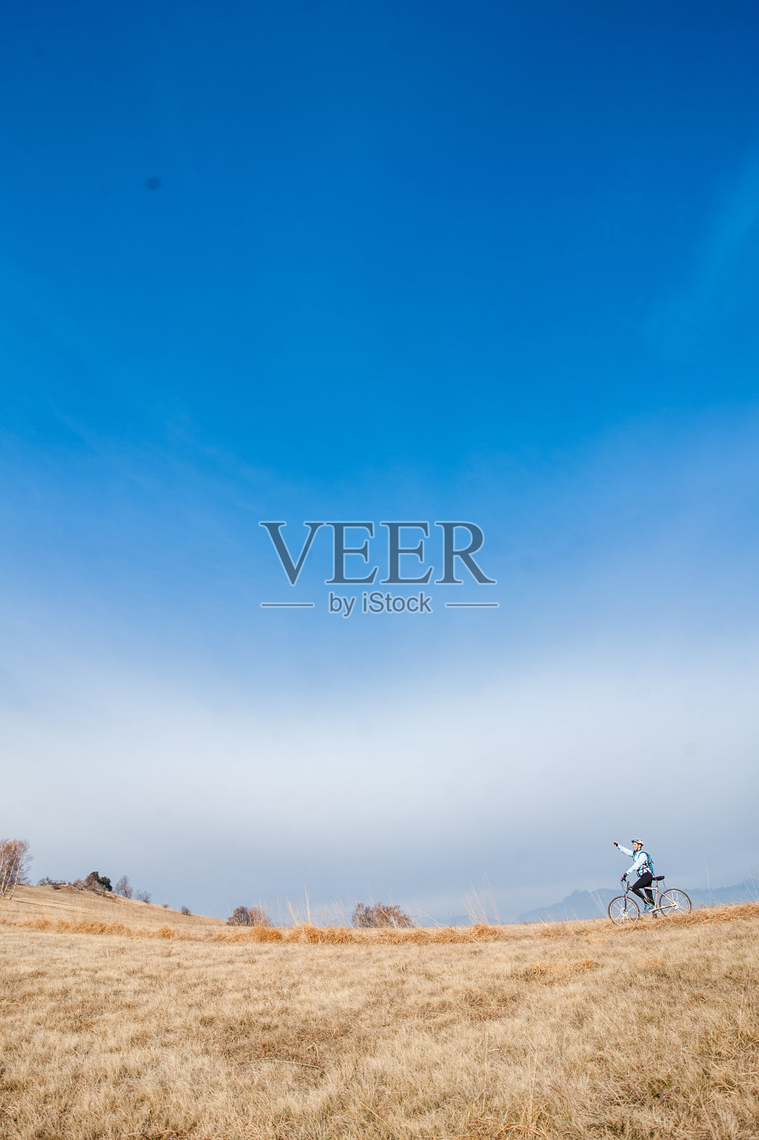 女越野自行车在草地上对着天空照片摄影图片