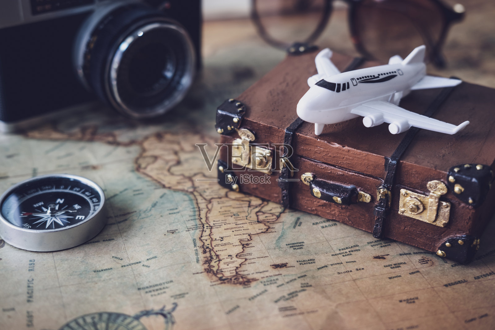 玩具飞机和行李箱在古董地图上复制空间，旅游概念照片摄影图片