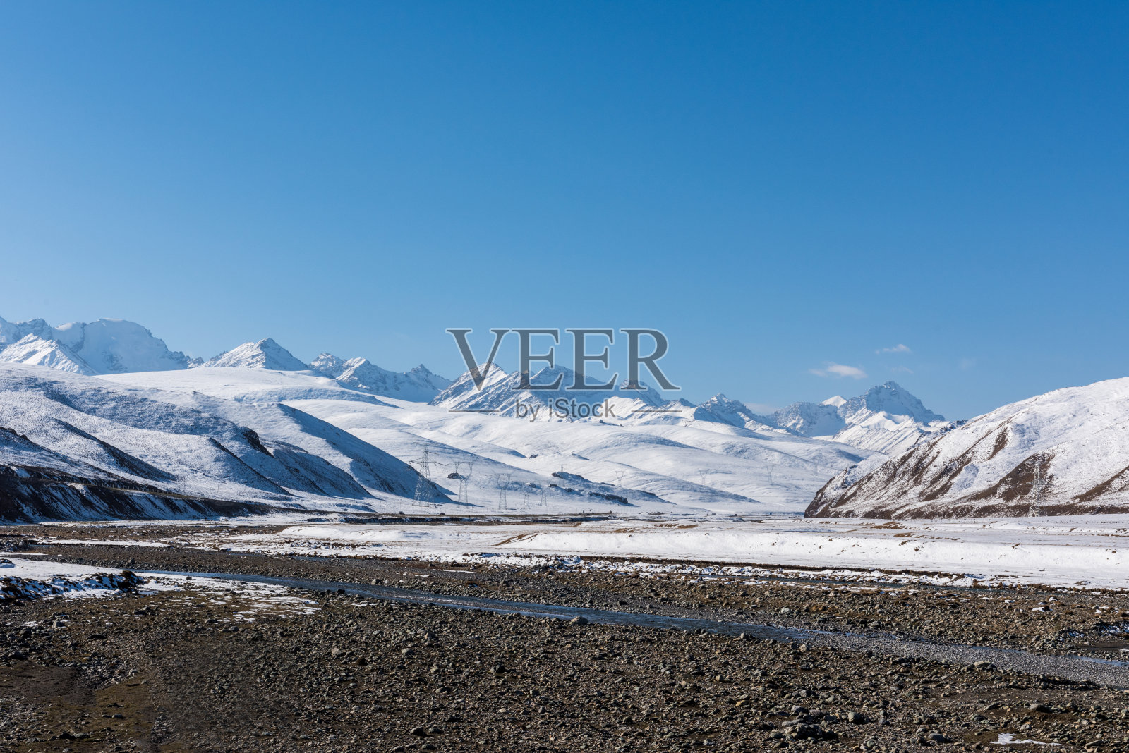 雪山背景为新疆独库高速公路，柏油路空有雪山照片摄影图片